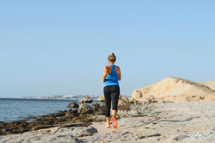 Woman with breast cancer running on a beach