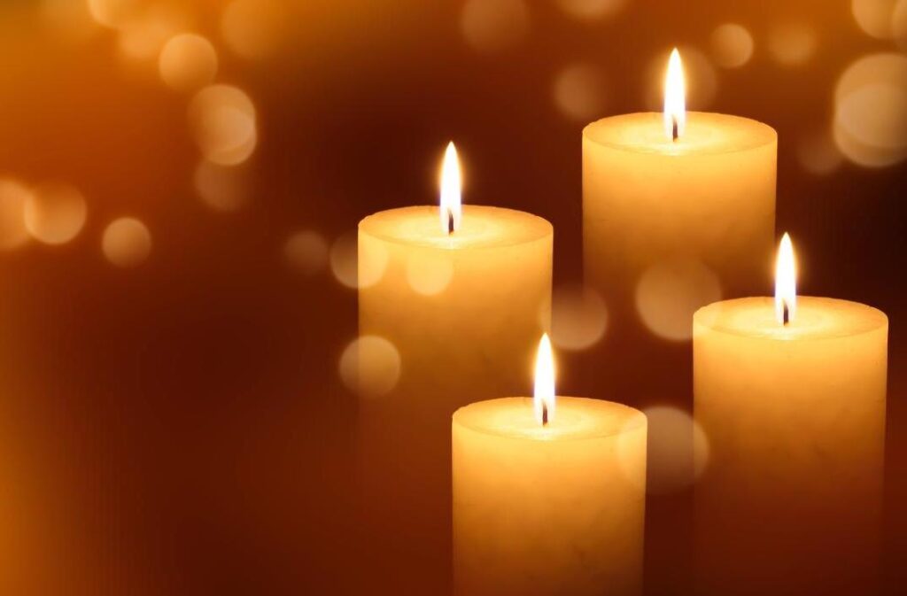 Four lit candles to signify grief after a breast cancer diagnosis