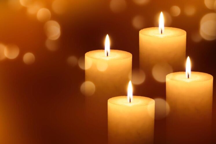 Four lit candles to signify grief after a breast cancer diagnosis